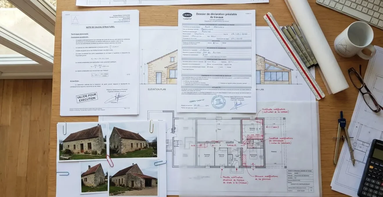 Vue en plongée d'un dossier complet de déclaration préalable de travaux avec formulaires CERFA, plans architecturaux annotés et note de calcul structure signée